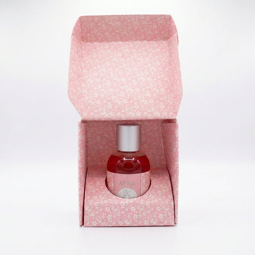 Perfume Ayra para mujer, frasco rosa con etiqueta decorativa y atomizador plateado, aroma floral dulce