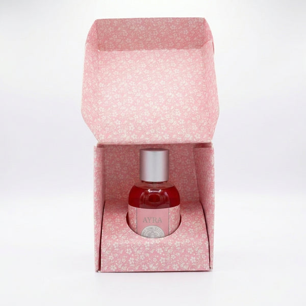 Perfume Ayra para mujer, frasco rosa con etiqueta decorativa y atomizador plateado, aroma floral dulce